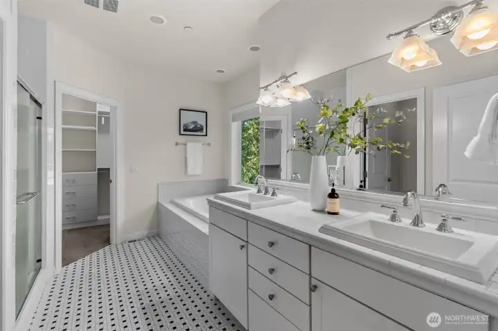 Primary bathroom features dual vanities, soaking tub, walk-in shower, and adjacent walk-in closet.