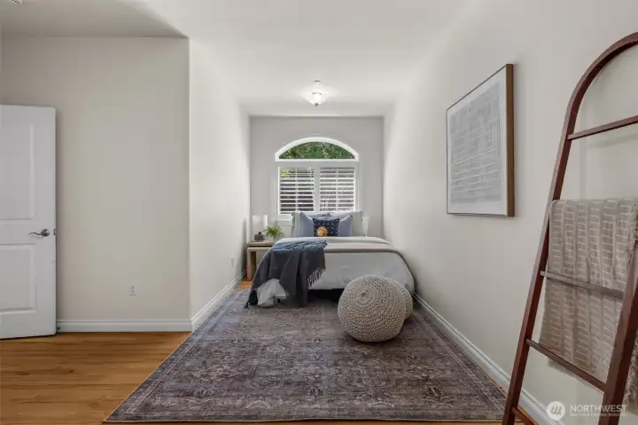 Additional upstairs bedroom provides versatile living space with architectural window accents.