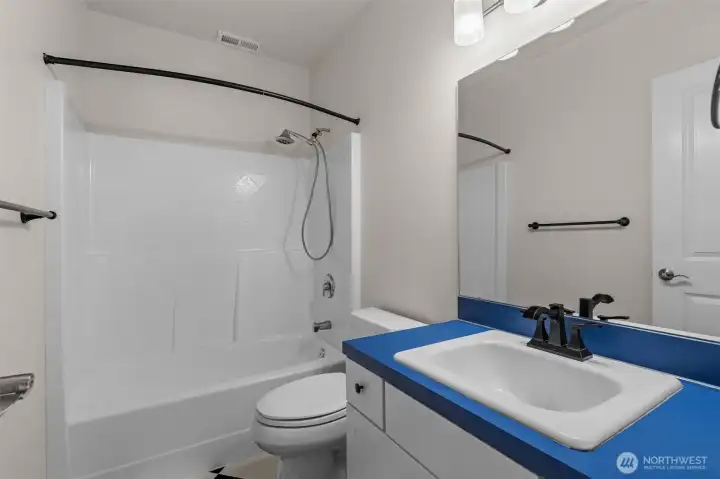 Lower level bathroom with neutral finishes and convenience access to lower level living spaces.