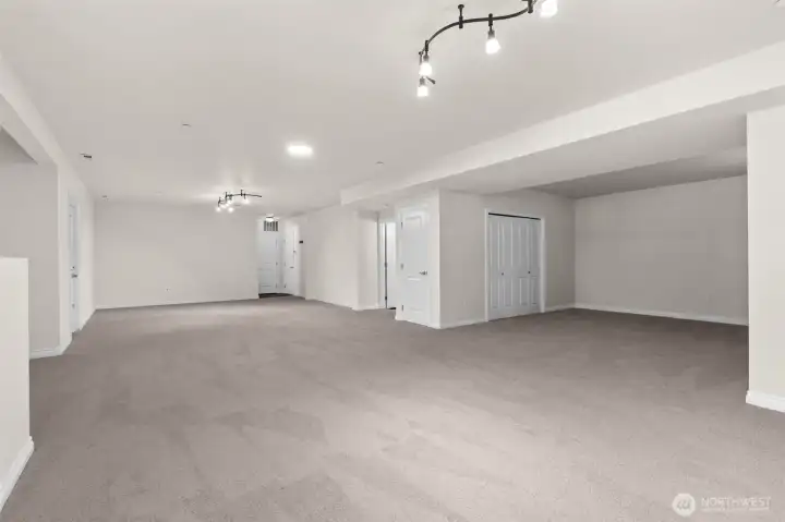 Additional view of the lower level highlighting the large recreation space with neural finishes and adaptable functionality.