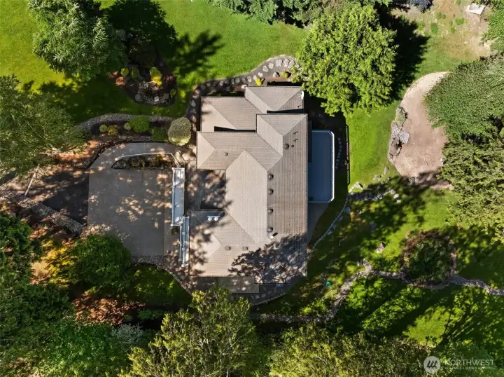 Aerial photo highlights the home’s positioning within the surrounding greenery and open yard space.