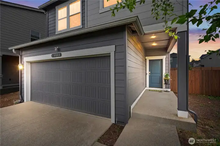 Spacious attached two-car garage with EV charging capability and additional driveway parking.