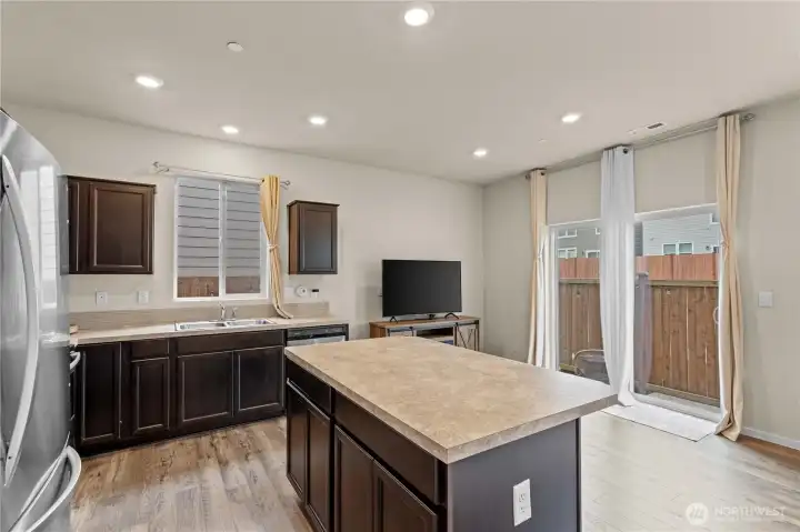 Large center island offers additional prep space, seating, and functionality.