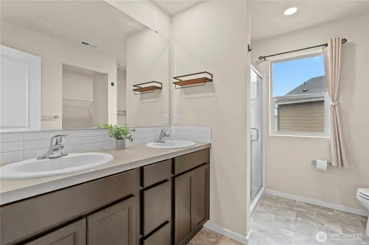 Well-appointed primary bath with dual vanity and modern finishes.