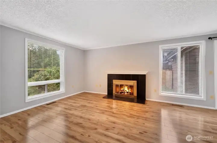 The spacious living room features beautiful wood flooring and flows seamlessly into the dining area, with direct access to the fully fenced yard The spacious living room features beautiful wood flooring and flows seamlessly into the dining area, with direct access to the fully fenced yard