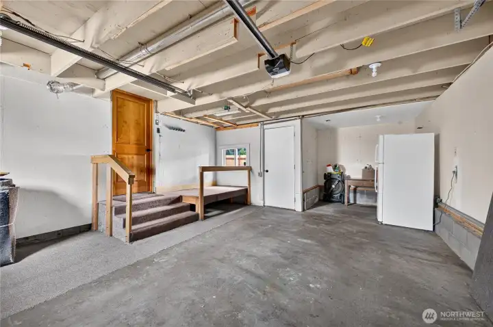 View of the garage with extra storage area. View of the garage with extra storage area.