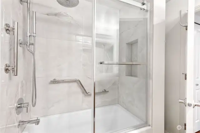 Marble-look tile, rainfall-style showerhead & soaking tub