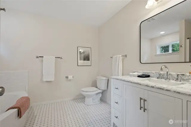 Beautiful bath with tub and freestanding shower.  Marbletop counters and custom tile floors!