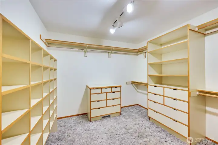 Primary suite closet is outfitting with closet organizing system.