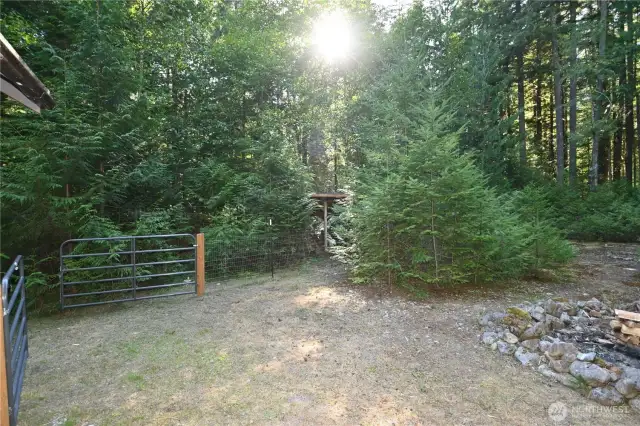 Gated entrance to fenced off back yard and wood storage {in background}