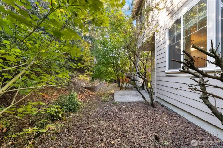 Backyard with covered patio.  There is no lawn to mow here as the flower bed is mostly of decorative lava rock (pebbles)