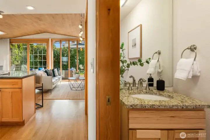 A charming powder room just off the family room, featuring warm wood accents and classic fixtures — a thoughtfully positioned and tastefully finished space that complements the home's natural, inviting aesthetic.
