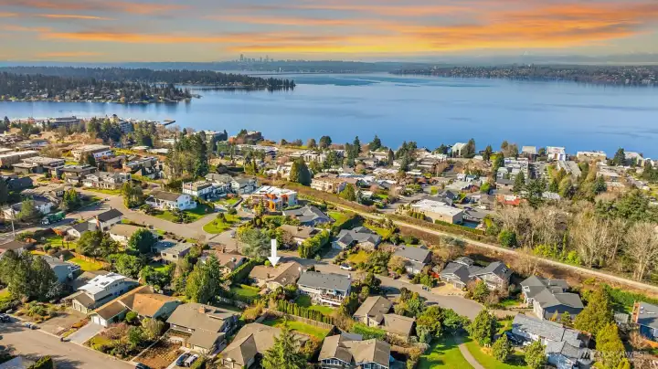 A breathtaking aerial view capturing the home's enviable Kirkland location, nestled within a tranquil residential neighborhood with sweeping vistas of Lake Washington's sparkling blue waters stretching to the horizon — a stunning reminder of just how close to the lake and all the beauty of the Pacific Northwest this exceptional property truly sits.
