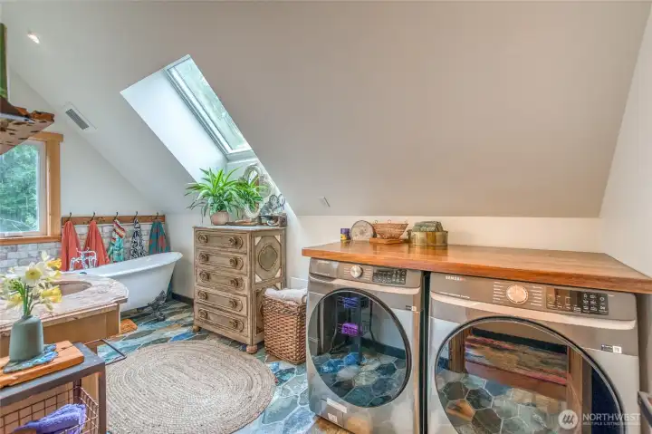 View from the doorway of the upstairs bathroom, with a washer and dryer.