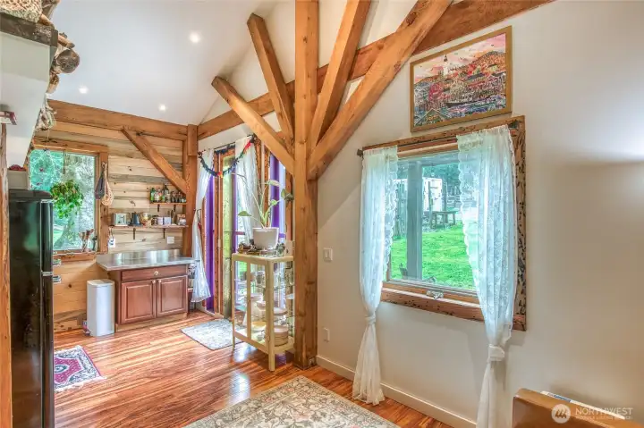 Beautiful sunburst pattern of beams at the kitchen entry, with lovely windows for soft light.