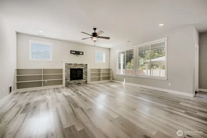 Large living room features abundant natural light, built-in shelving, and a cozy fireplace as the centerpiece of the space. Large living room features abundant natural light, built-in shelving, and a cozy fireplace as the centerpiece of the space.