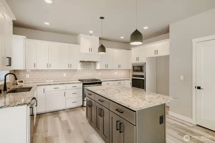Beautiful kitchen features quartz countertops, abundant cabinetry, stainless steel appliances, and a large center island. Beautiful kitchen features quartz countertops, abundant cabinetry, stainless steel appliances, and a large center island.