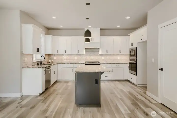 Oversized island provides additional prep space, storage, and seating for casual dining and entertaining. Oversized island provides additional prep space, storage, and seating for casual dining and entertaining.