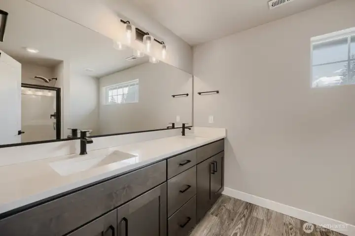 Spacious guest bath showcases dual sinks, quartz counters, abundant storage, and designer finishes throughout. Spacious guest bath showcases dual sinks, quartz counters, abundant storage, and designer finishes throughout.