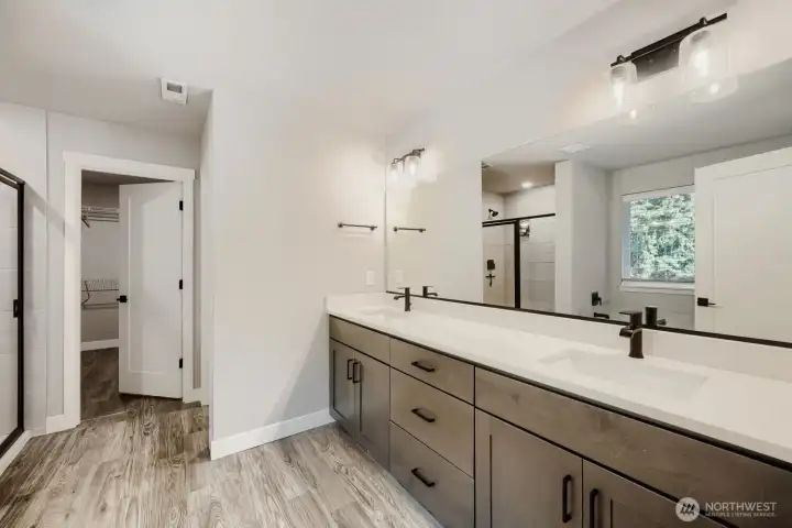 Luxurious primary bath features an expansive dual-sink vanity, quartz countertops, and abundant storage. Luxurious primary bath features an expansive dual-sink vanity, quartz countertops, and abundant storage.
