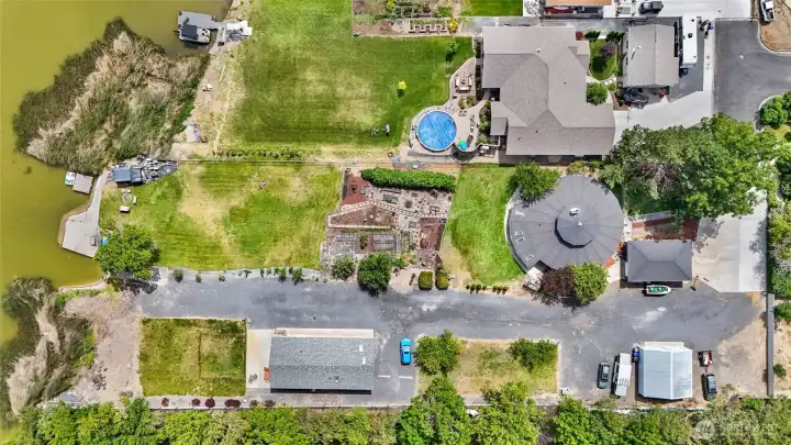 This home is nestled in a cul-de-sac among large shade trees. The dog run front yard is fully fenced, and the north side of the yard is fenced down to the waterfront.
