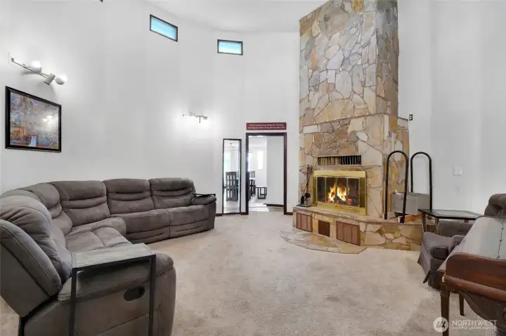 The center of the home is the living room where heart and hearth meet below vaulted ceilings that let the light shine in through the upper windows.