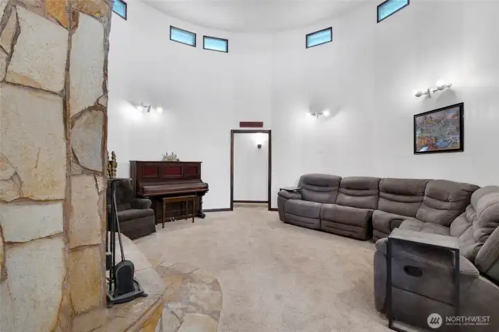 Multiple lights and natural lighting through multiple windows light up the living room. The piano by the doorway gives you an idea of how much space you have in here.