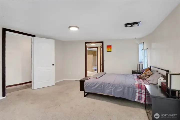 There's room for extra seating in this primary bedroom where you'll enjoy his and her closets as you enter the doorway to the primary bath.