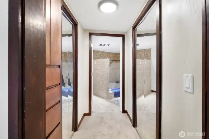 Primary bedroom closets across from each other are in the hallway to the custom primary bath with jetted tub and shower.