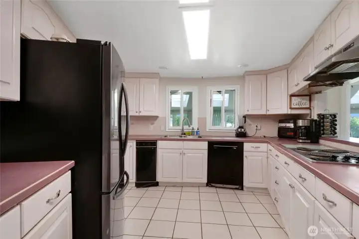 You'll enjoy stainless steel appliances as well as black appliances, including a dishwasher and trash compactor in this spacious kitchen with a multitude of cupboards!