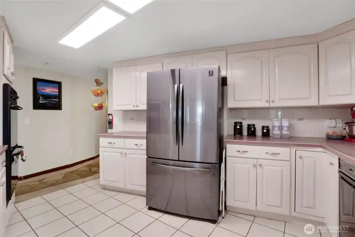 You'll enjoy the antique white cupboards as they surround the stainless steel refrigerator.