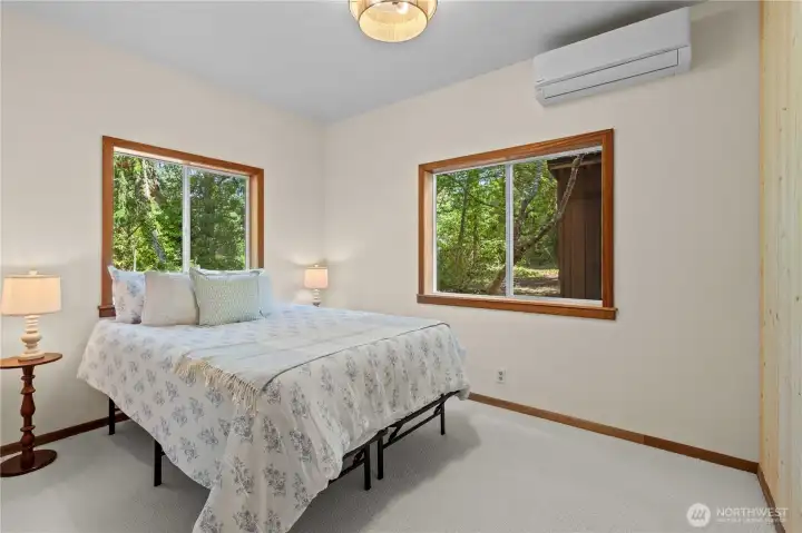 Main-floor bedroom with peaceful wooded views and abundant natural light. Main-floor bedroom with peaceful wooded views and abundant natural light.