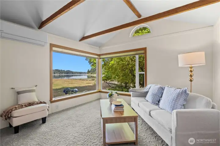 Living room with exposed beams, abundant natural light, and panoramic water views. Living room with exposed beams, abundant natural light, and panoramic water views.