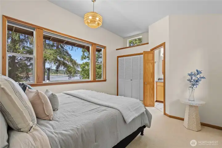 Primary bedroom with large windows overlooking the private waterfront property. Primary bedroom with large windows overlooking the private waterfront property.