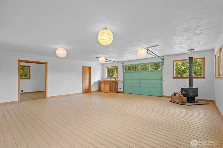 Spacious detached bonus building features an open layout with vaulted ceilings, wood stove, built-in cabinetry, and endless possibilities for recreation, hobbies, or workspace. Spacious detached bonus building features an open layout with vaulted ceilings, wood stove, built-in cabinetry, and endless possibilities for recreation, hobbies, or workspace.