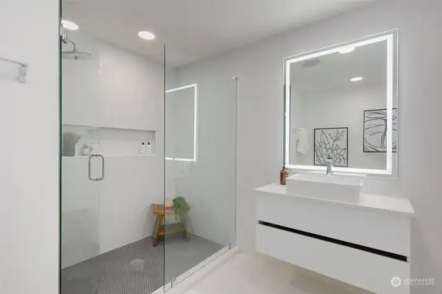 Bathroom features a ceramic tile walk-in shower and a floating quartz vanity with a daylight mirror.