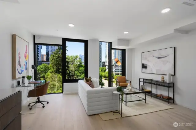 Living area features operable floor-to-ceiling windows, engineered hardwoods, ceiling Mitsubishi mini-split, and ample space for a home office.