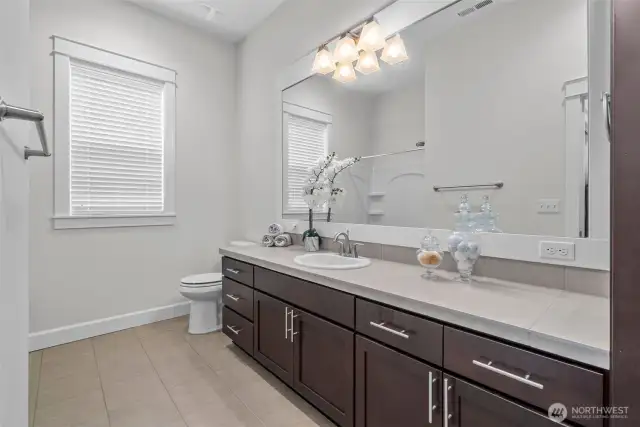 Located just off the second bedroom, this beautifully appointed full bathroom offers both elegance and function. It features bathtub, perfect for unwinding at the end of the day. A sleek vanity with ample storage, polished hardware, and a large mirror adds a refined touch, while modern lighting and tasteful fixtures complete the space. Whether for guests or daily use, this bathroom delivers comfort with a timeless aesthetic.