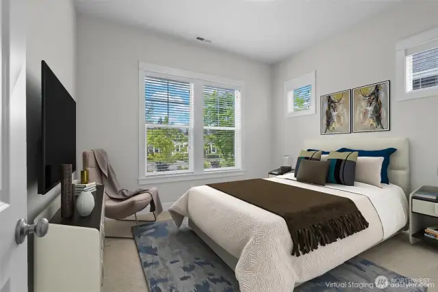 Nestled at the front of the home, the second spacious bedroom offers both comfort and charm. Positioned adjacent to the second full bathroom, this inviting retreat is bathed in natural light from two beautifully wood-wrapped windows and elegant transom windows above. The thoughtful window design allows sunlight to pour in while preserving privacy and adds a touch of architectural sophistication that elevates the room’s serene ambiance.