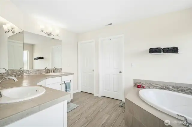 Primary suite bathroom with soaking tub, walk-in shower, double sinks and walk-in closet.