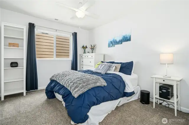Upper level bedroom with ceiling fan.