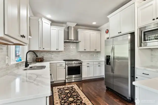 Stunning kitchen with stainless appliances and custom cabinetry that includes pull out drawers.
