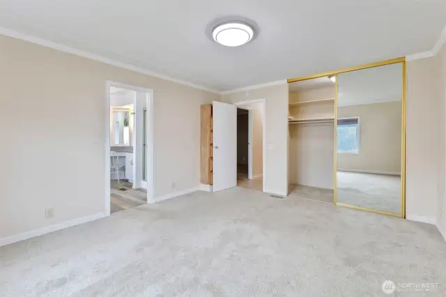 Primary bedroom showing the large closet and attached bathroom. Behind the door is a built-in cabinet as well.