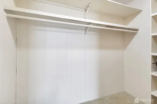 Primary bedroom closet with shelves at the right.