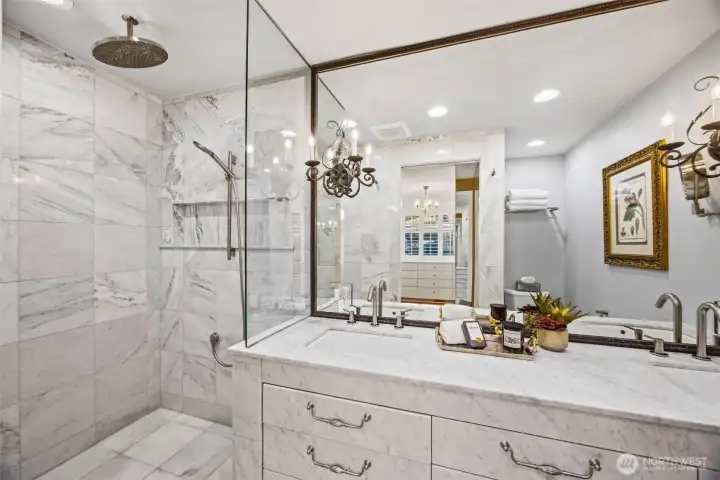 Absolute stunning primary bathroom with custom vanity built in place and entirely clad in Bianco Carrara polished marble design. Heated floors and Grecian white marble in the shower.