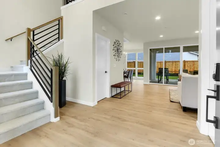 A soaring entryway offers a dramatic first impression, drawing your eye straight through to the lush backyard.