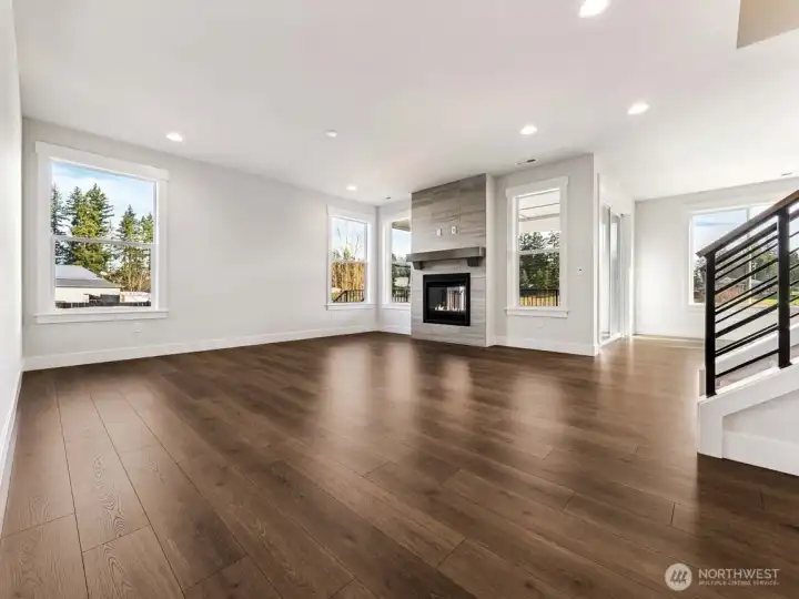 Spacious living room with dramatic two-sided fireplace. Warm, yet still light and bright.