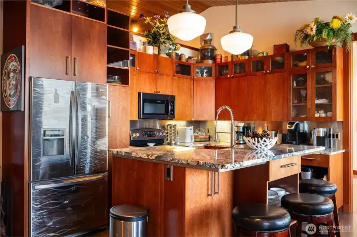 The kitchen has all stainless steel appliances and incredible hand crafted cabinets. The custom refrigerator matches that of the kickplates on the stairways.
