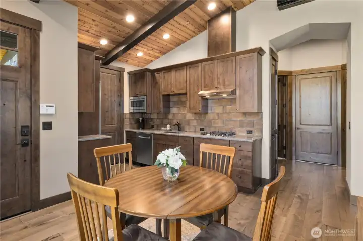 Kitchen area with gas cooktop, refrigerator, microwave, and dishwaher