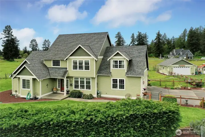 Drone view of front of home, talk about curb appeal! Just a beautiful, and quite well-maintained, custom home. A bit of country yet close to all amenities!